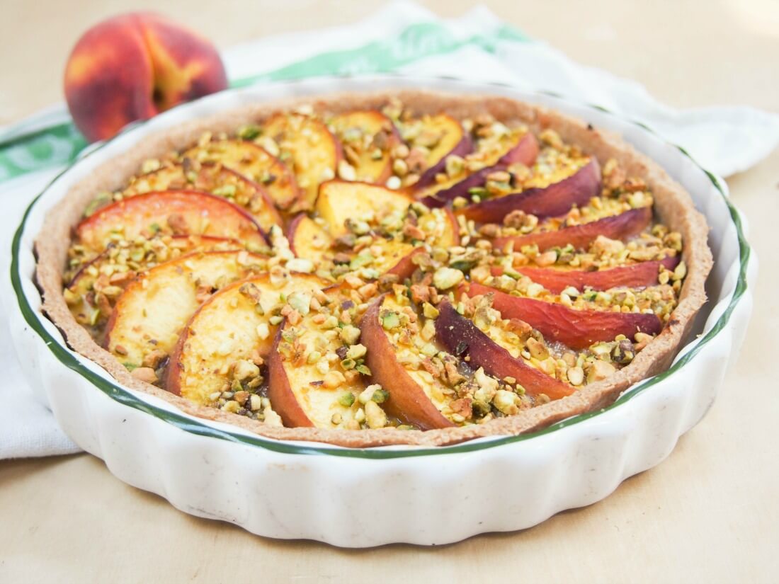 peach and pistachio tart in dish viewed from side