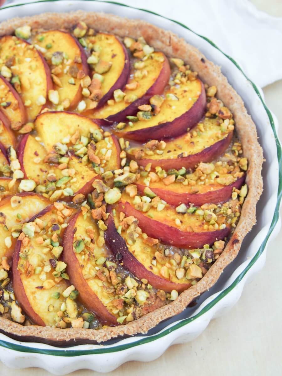 partial view of peach and pistachio tart in dish