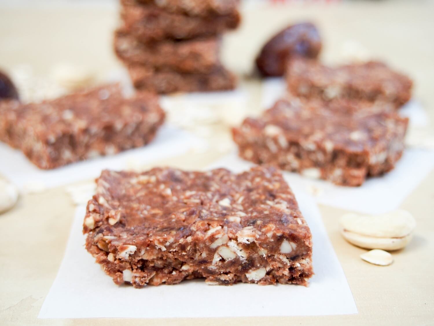 no bake chocolate cashew bars on individual pieces of parchment