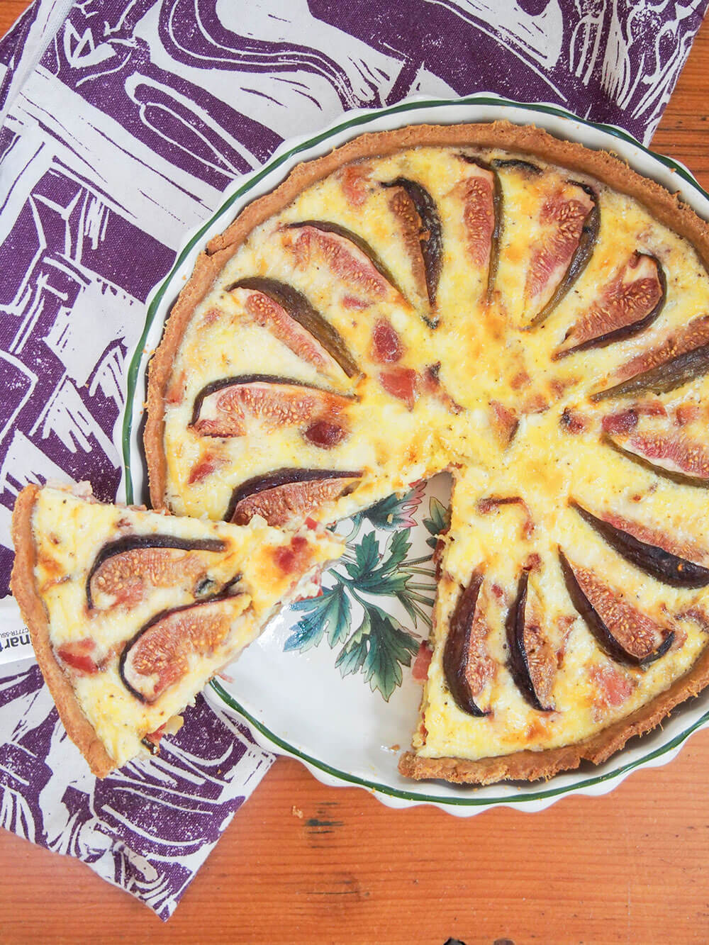 fig, goat's cheese and bacon quiche from overhead with slice cut out