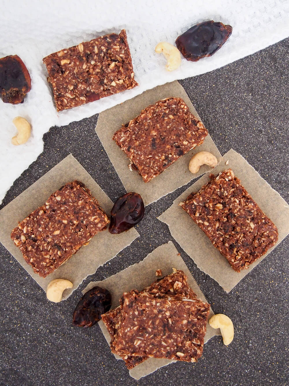 no bake chocolate cashew bars on pieces of parchment from above
