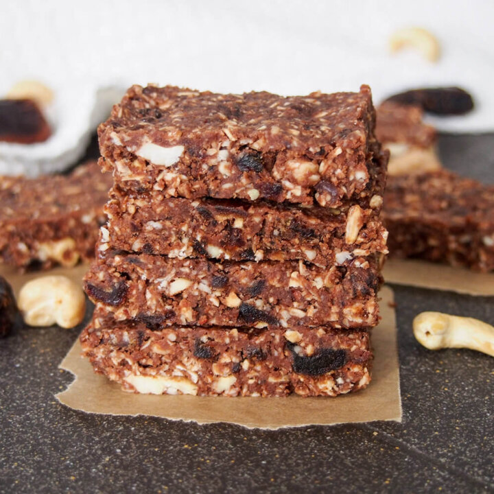 stack of no bake chocolate cashew bars with more behind