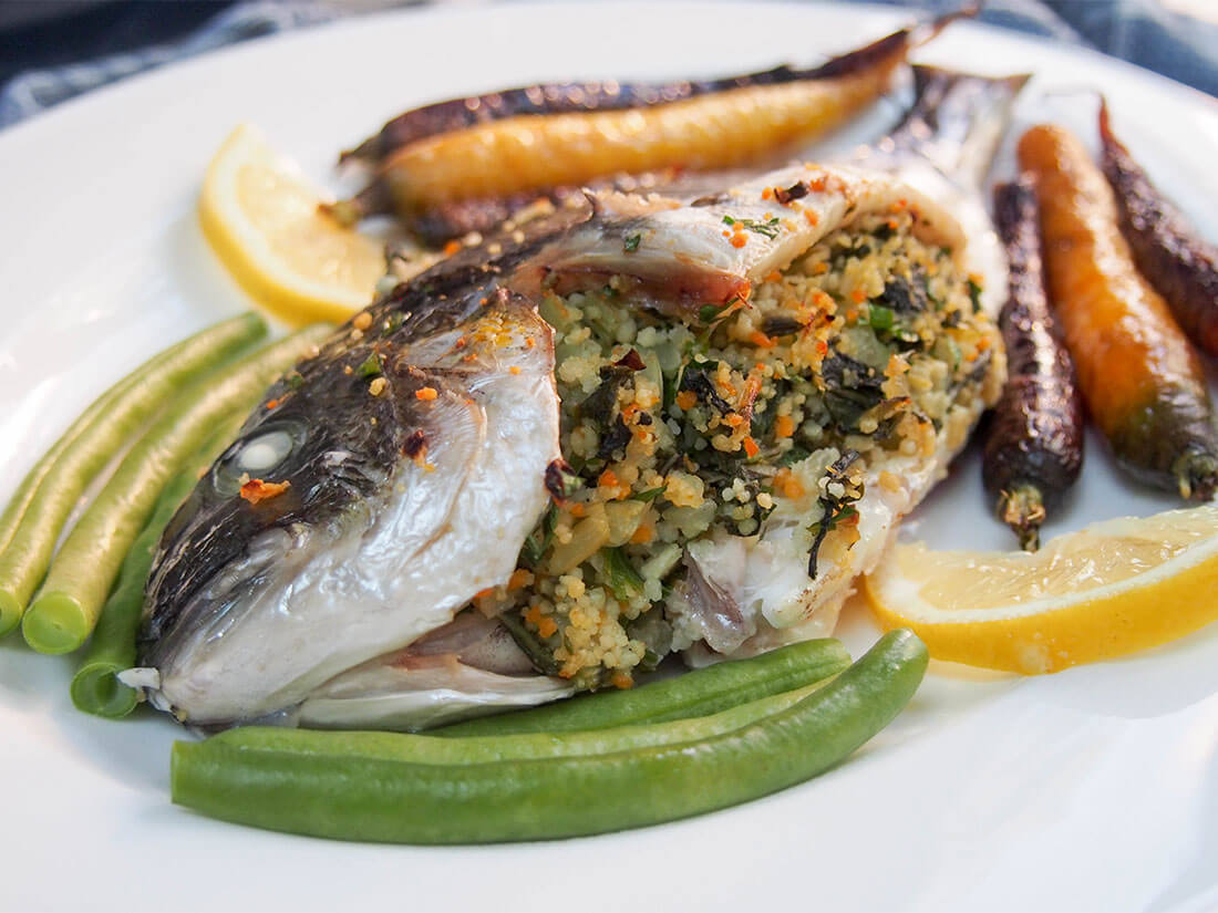 chard couscous stuffed fish on side with vegetables around