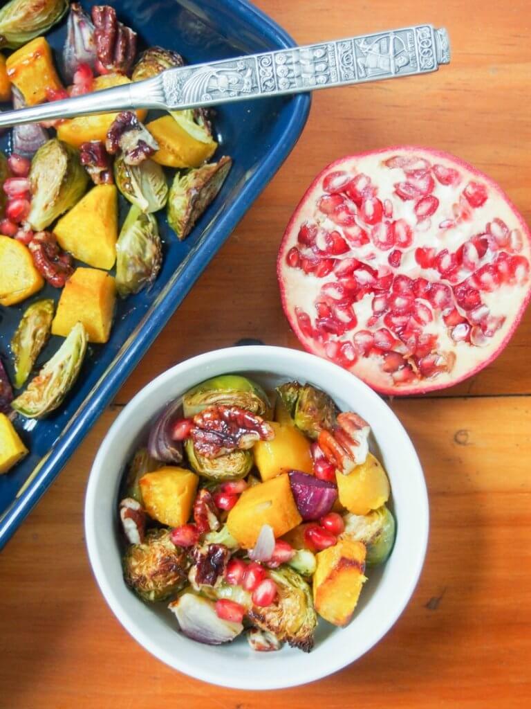 This acorn squash & Brussel sprout side dish is topped with candied pecans, pomegranate and a tasty dressing. Perfect as a holiday side, healthy too. (vegan, gluten-free)