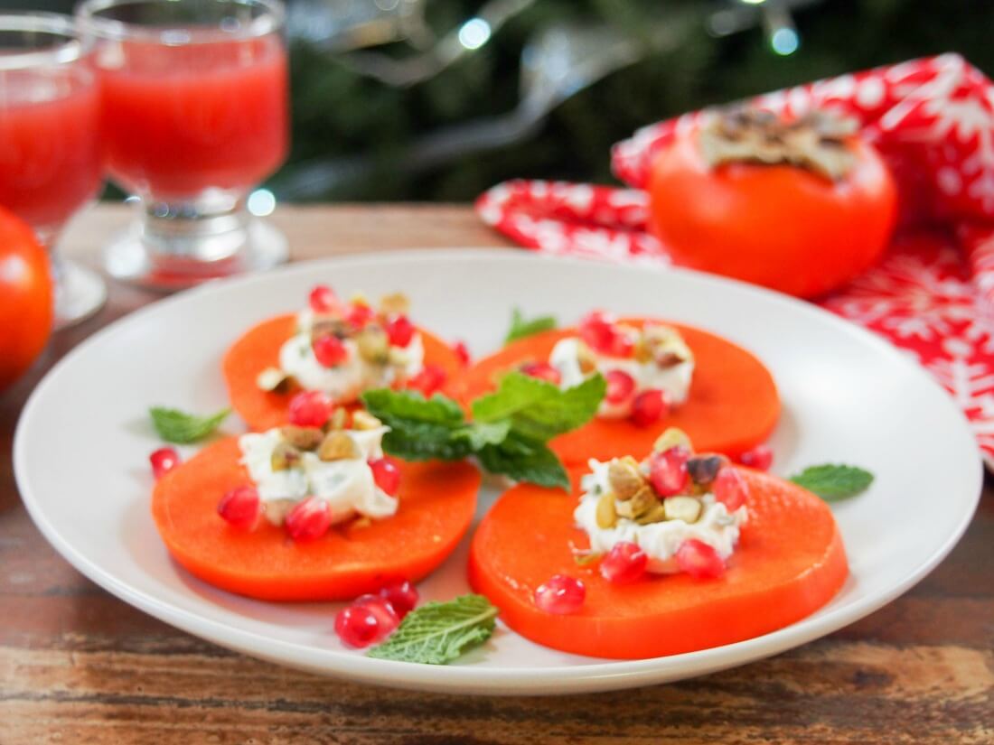 This easy persimmon appetizer is a tasty, colorful addition to any appetizer plate. Incredibly quick to make, a delicious mix of textures. plate of easy persimmon appetizer with minted mascarpone with a persimmon and glasses behind