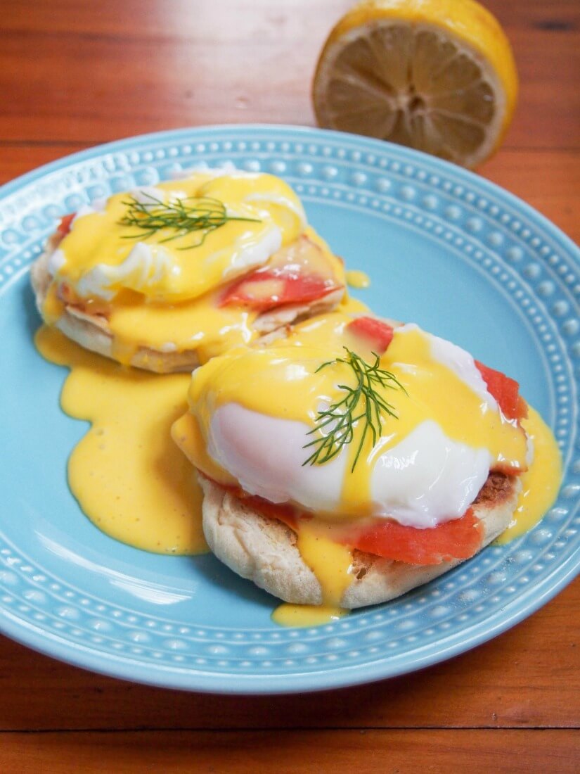 Two stacks of eggs Royale on plate with lemon behind