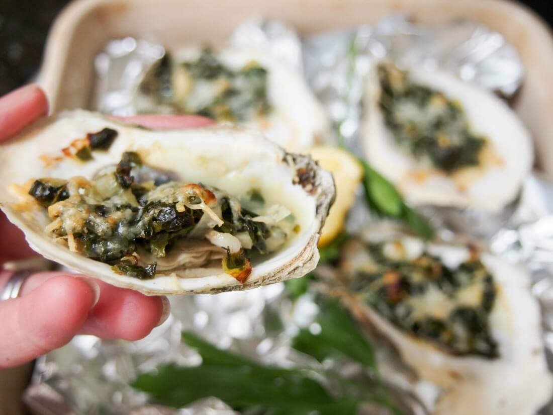 holding an oyster in hand above dish with rest