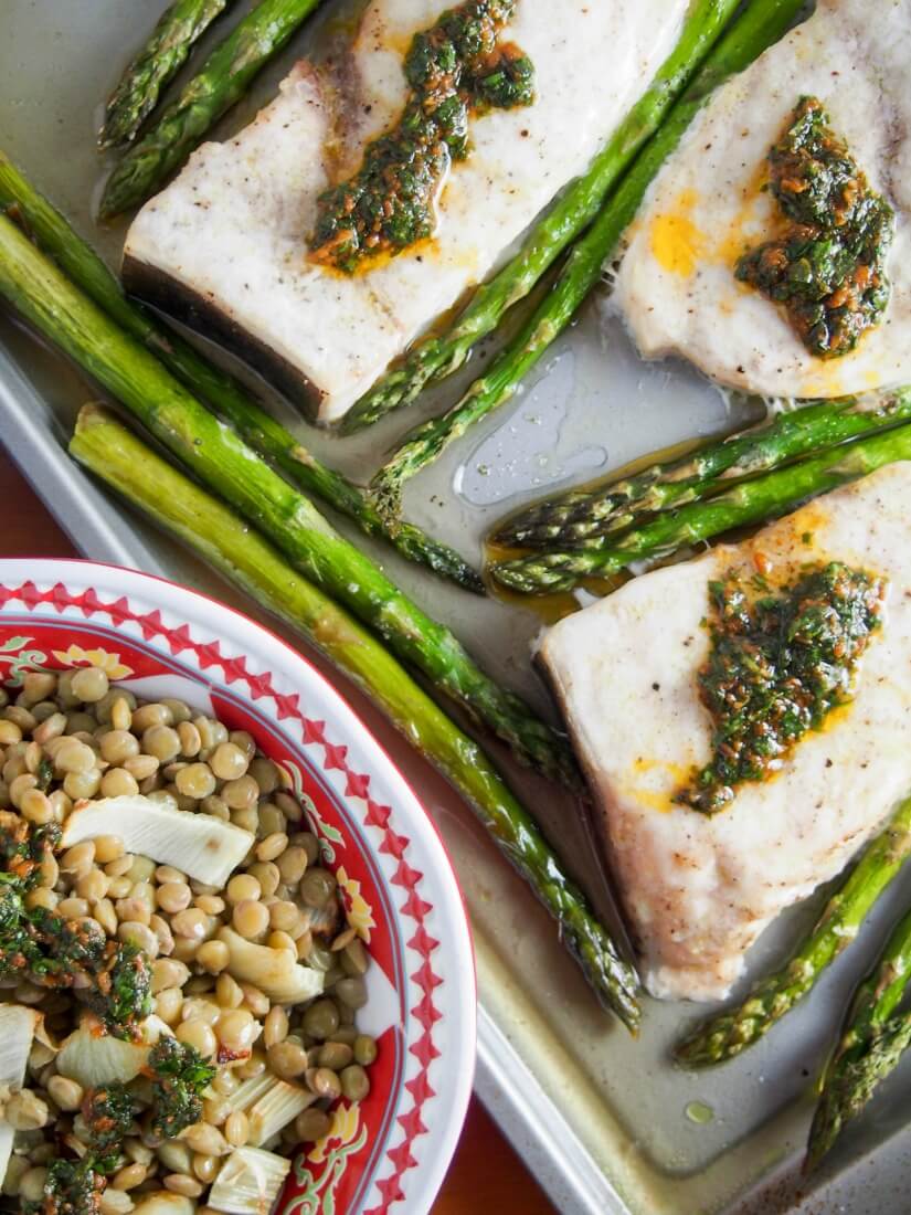 swordfish topped with chermoula sauce along with asparagus and green lentils