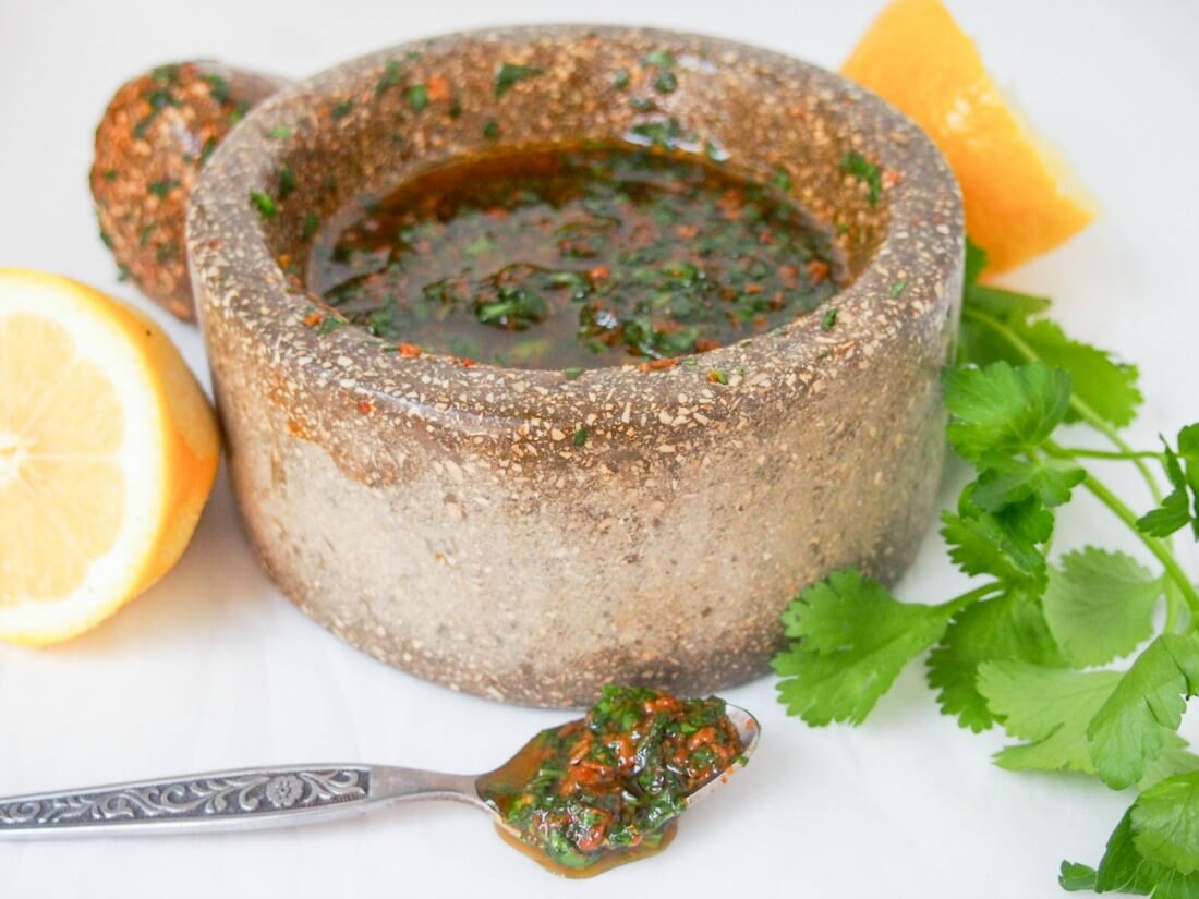 chermoula sauce in mortar with spoon of sauce in front