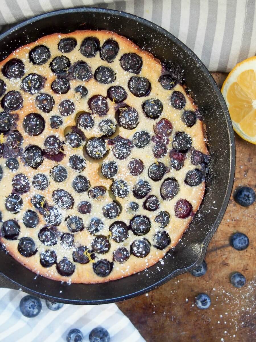 Blueberry clafoutis viewed from overhead with sprinkle of powdered sugar on top