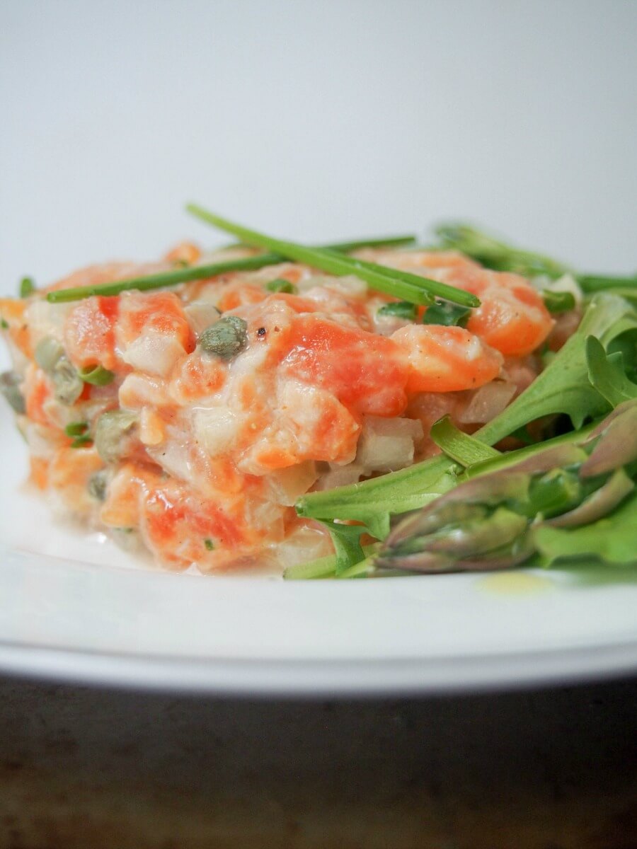 salmon tartare topped with chives viewed from side