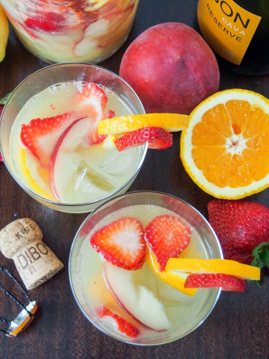 glasses of cava sangria viewed from overhead with fruit to side