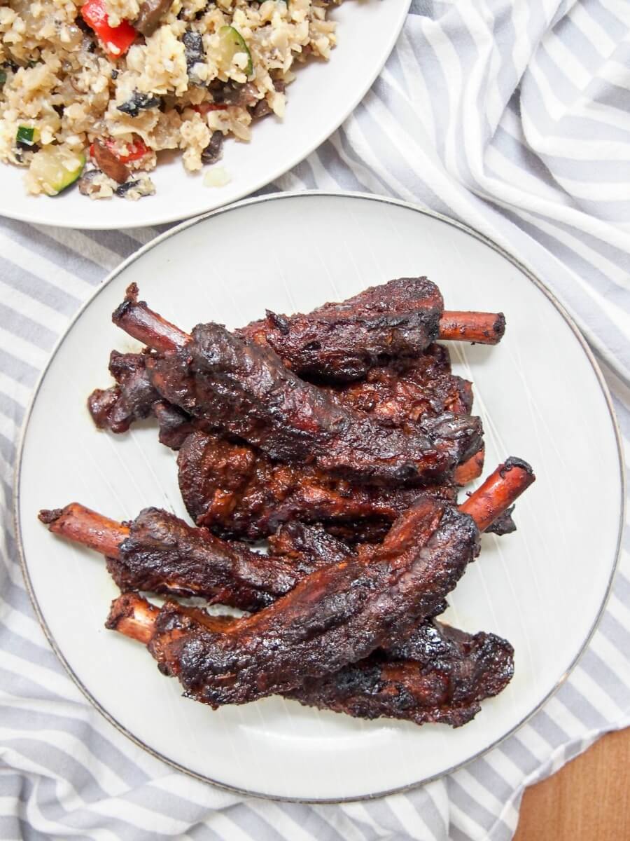 Chinese spare ribs on plate from overhead with plate of fried rice above
