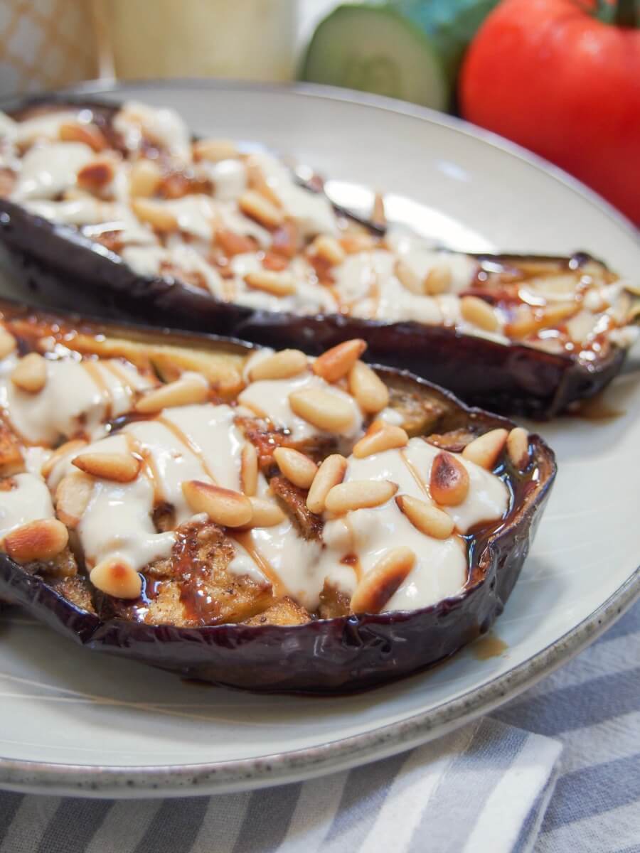 Roasted eggplant with tahini is a delicious appetizer or mezze dish that you'll find in Israel and other parts of the region. It's incredibly easy to make and full of fantastic flavor. side view of roasted eggplant with tahini