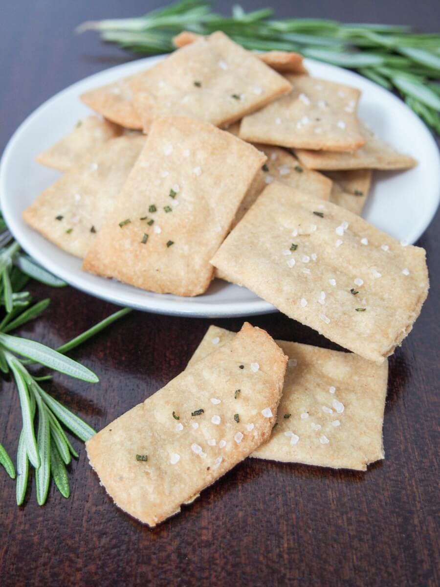 whole wheat olive oil crackers on plate with some spilling over in front