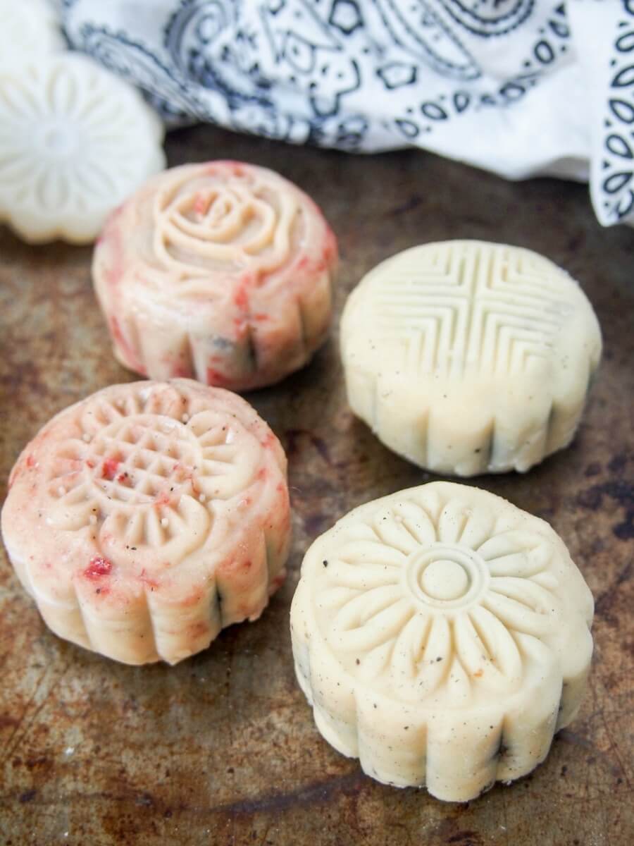 four snow skin mooncakes with different designs printed on top 
