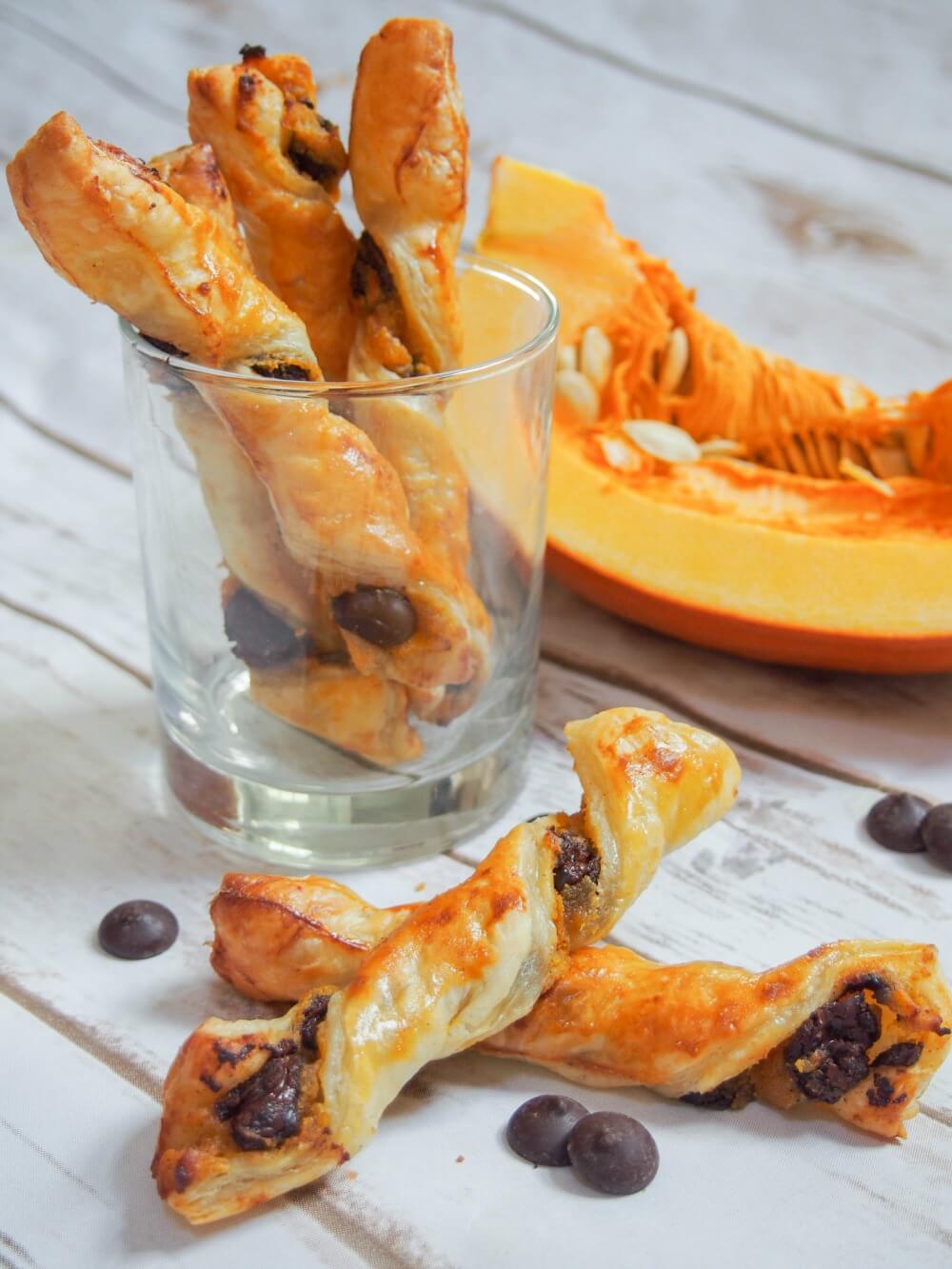 Whether you're a pumpkin fan or not, these chocolate pumpkin pastry twists are sure to be a hit. A deliciously simple combination with a bit of sweet, a bit of spice, crisp pastry and soft filling. Chocolate pumpkin pastry twists in glass with two resting on each other in front
