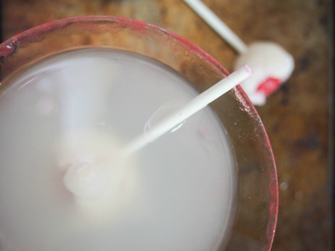 lychee martini from overhead with lychee on stick garnish