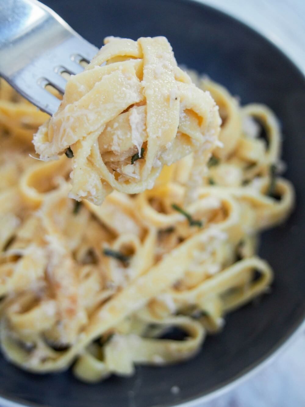 forkful of homemade pumpkin pasta pasta on fork above bowl