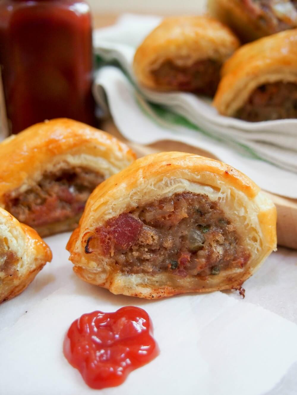 close up of sausage roll with ketchup in front
