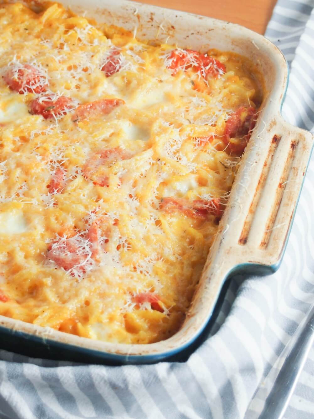 This cheesy orzo pasta bake is comfort food on a plate, with a slightly healthy twist. With lots of cheese and veggies, it's a great vegetarian meal. part view of dish of cheesy orzo pasta bake