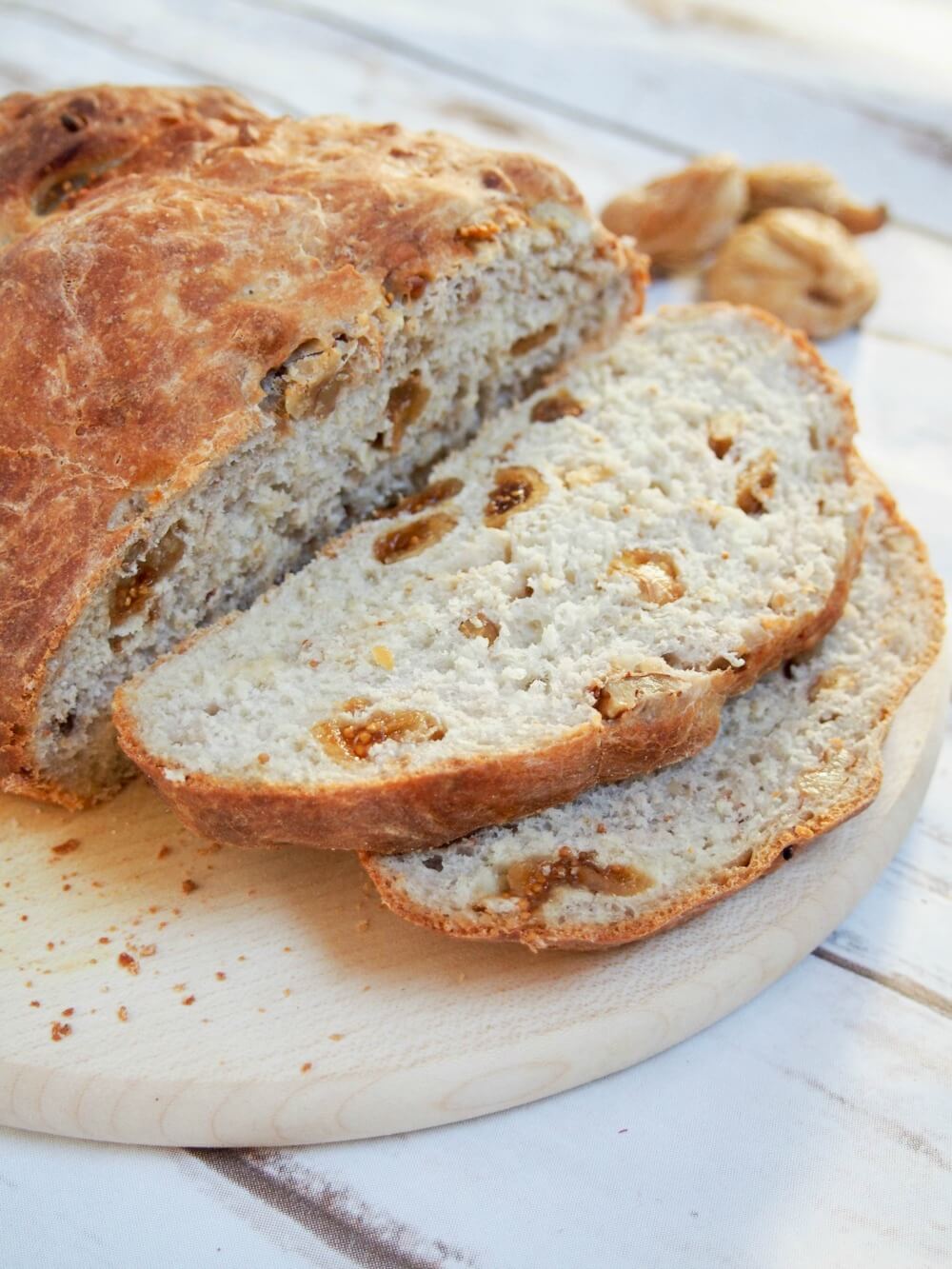 fig and walnut bread with two slices sitting in front of rest of loaf