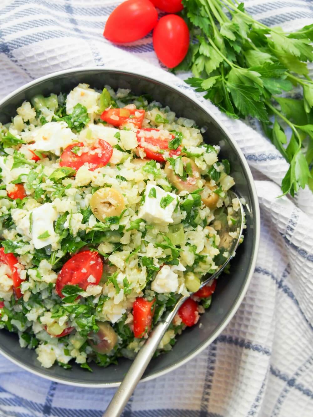 bowl of cauliflower rice salad with spoon in side of bowl