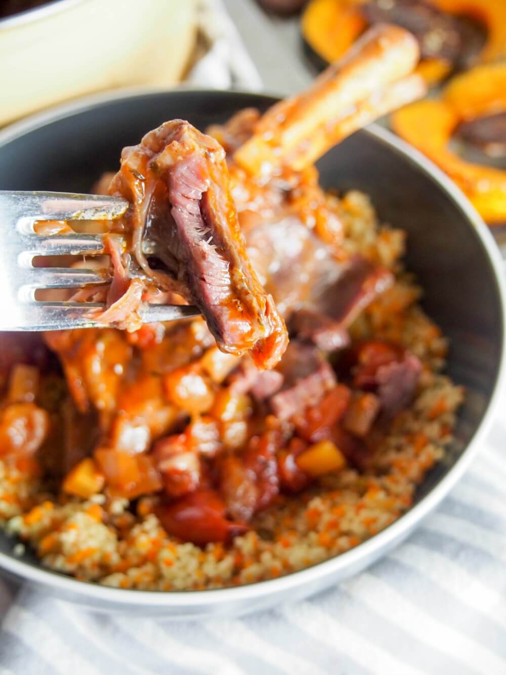 braised lamb shanks with forkful held above bowl