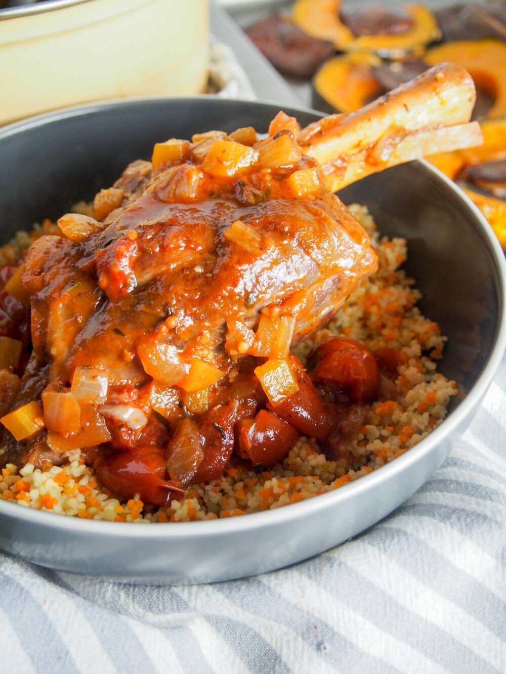 braised lamb shank covered in sauce served over couscous