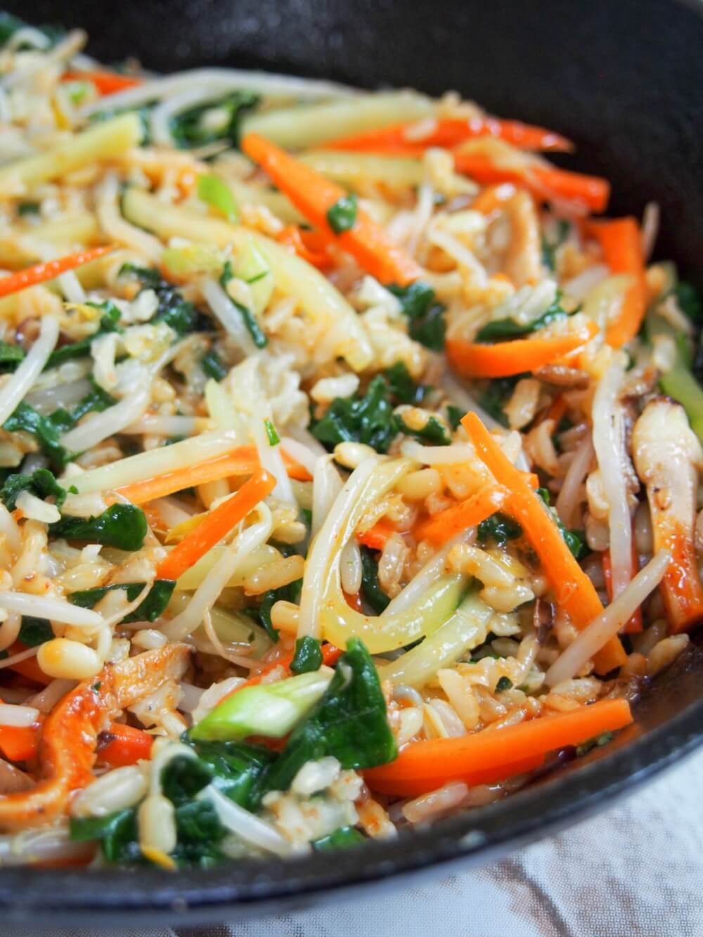 mixed vegetarian bibimbap in skillet from side
