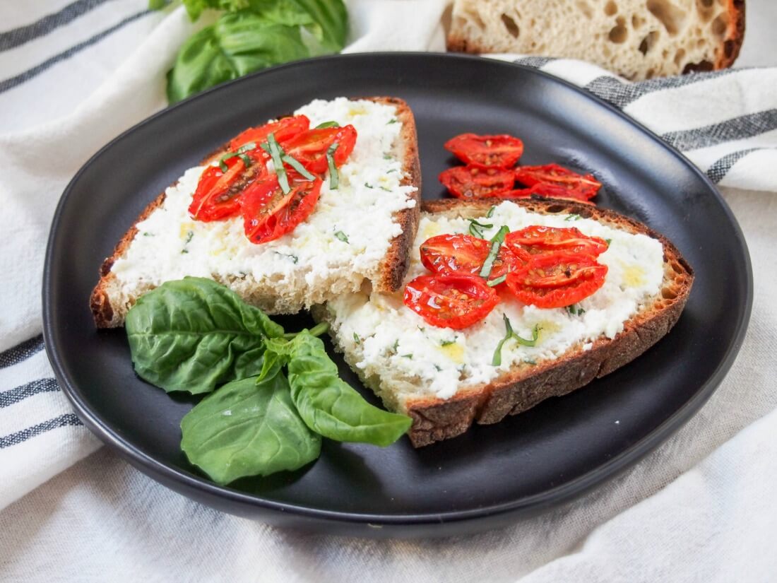 Plate with two slices of basil ricotta toast