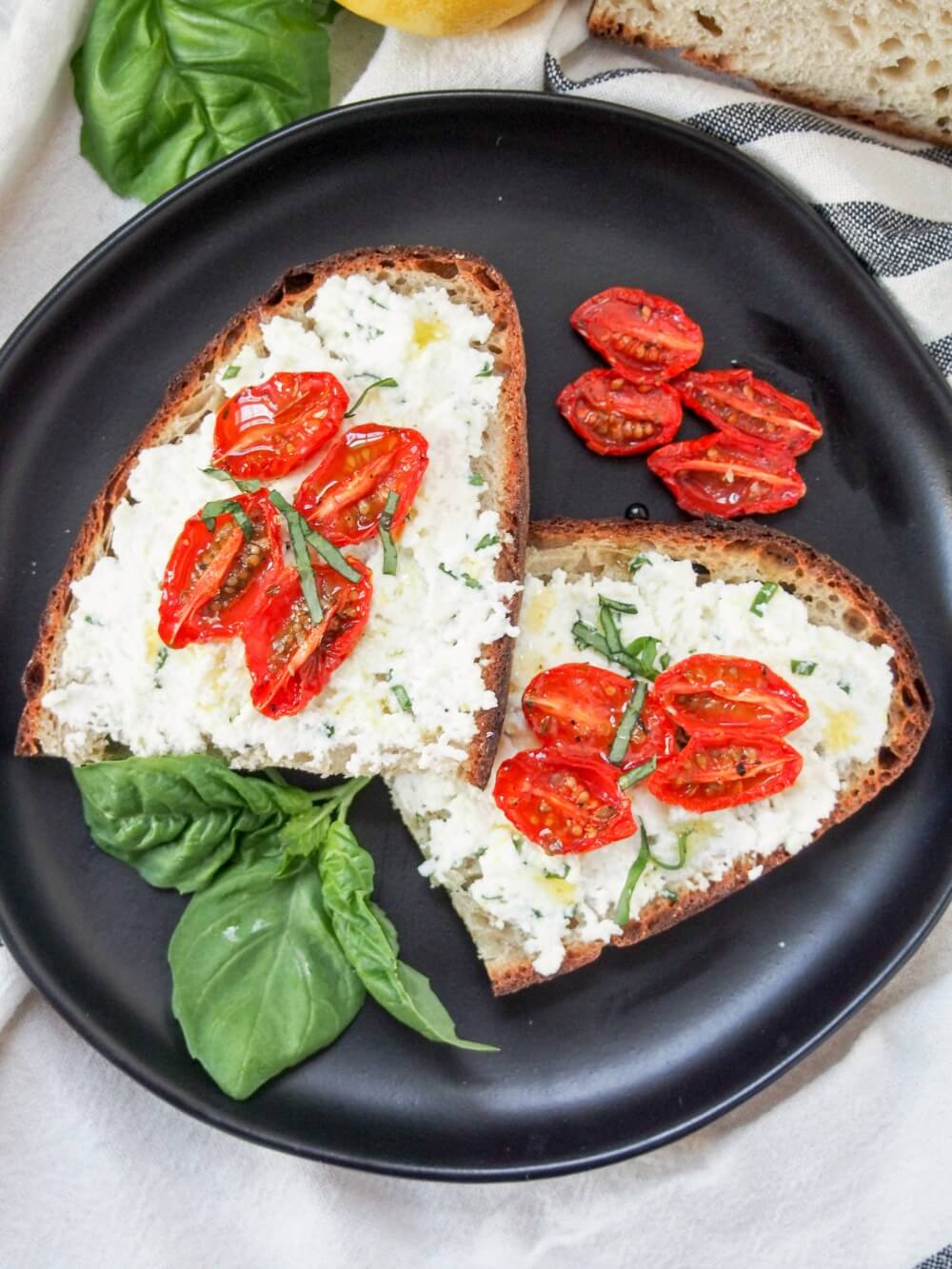 Basil ricotta toast with slow roasted tomatoes on top and to the side