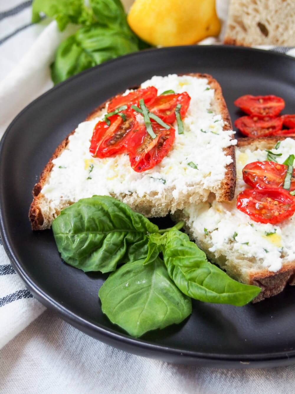 Basil ricotta toast topped with slow roasted tomatoes and a drizzle of olive oil