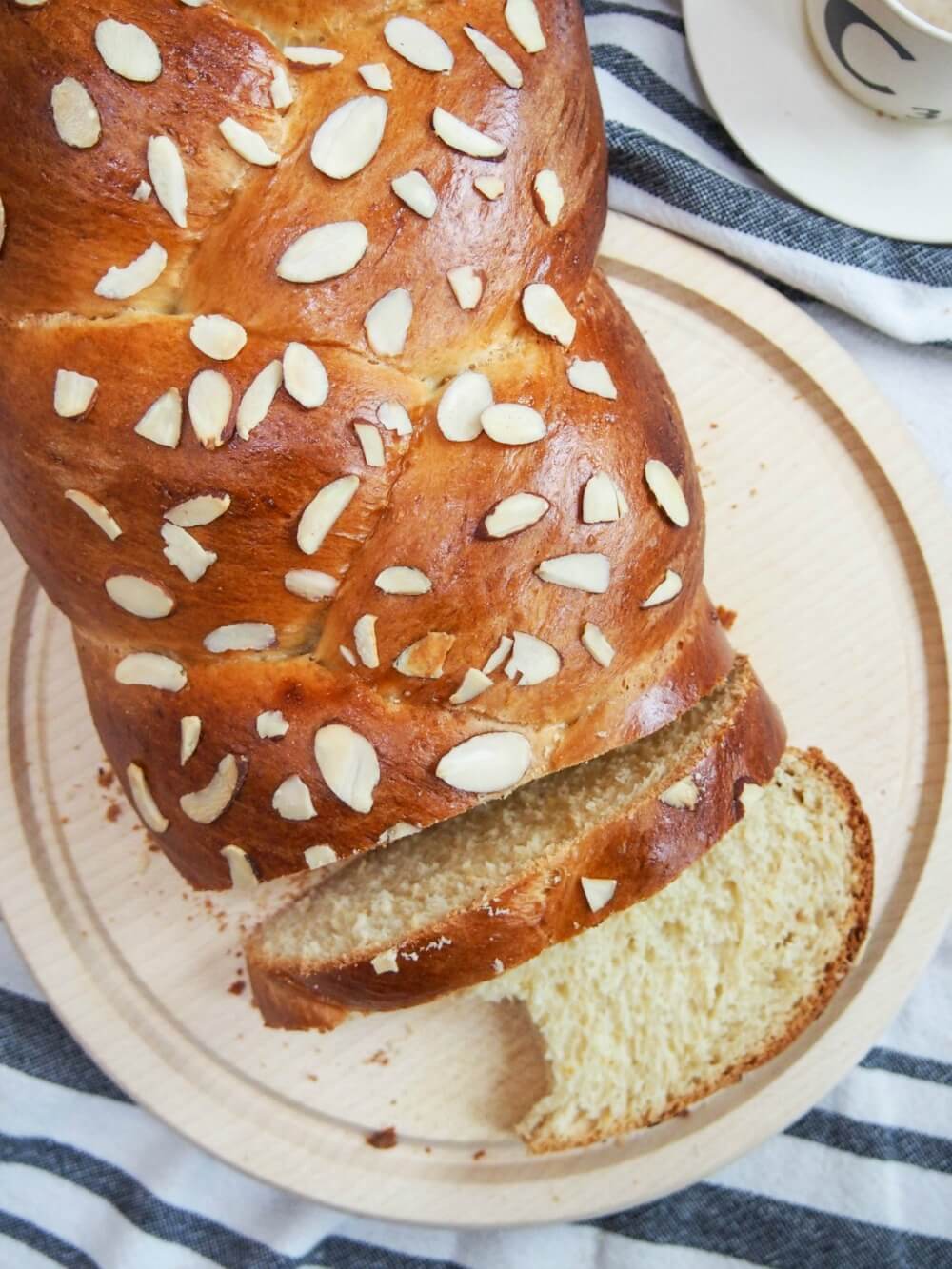 loaf of Tsoureki Greek Easter bread viewed from above with a couple of slices cut from loaf