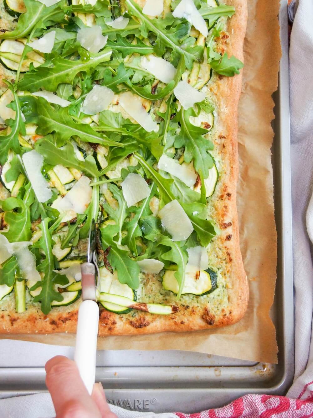 cutting into green pizza