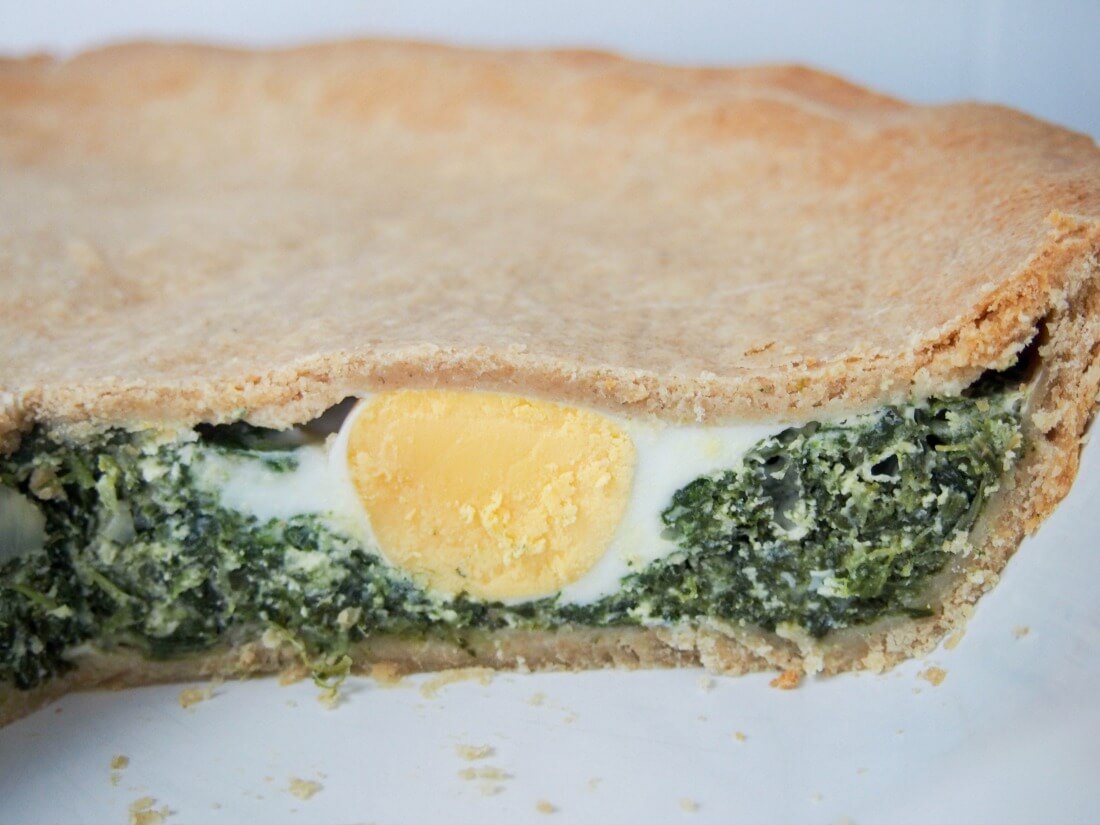 side view of sliced torta pascualina showing egg inside