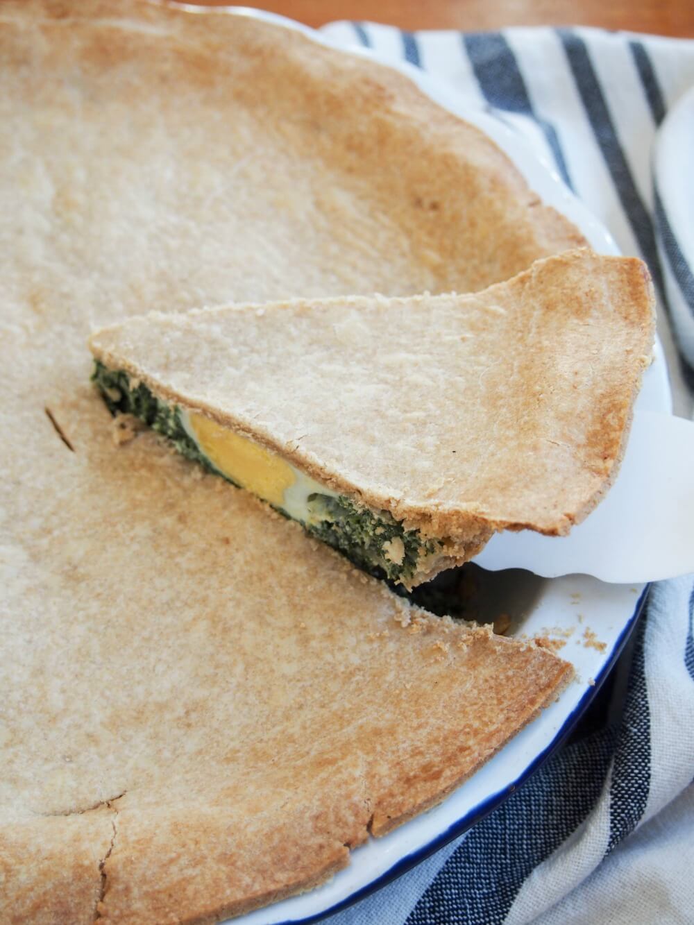 lifting slice of torta pascualina from rest of pie
