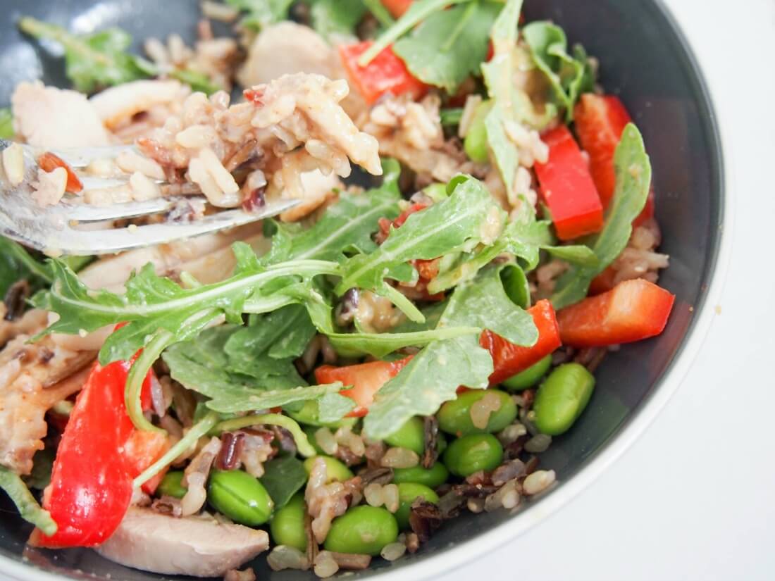 rice, chicken and salad ingredients mixed up ready to eat
