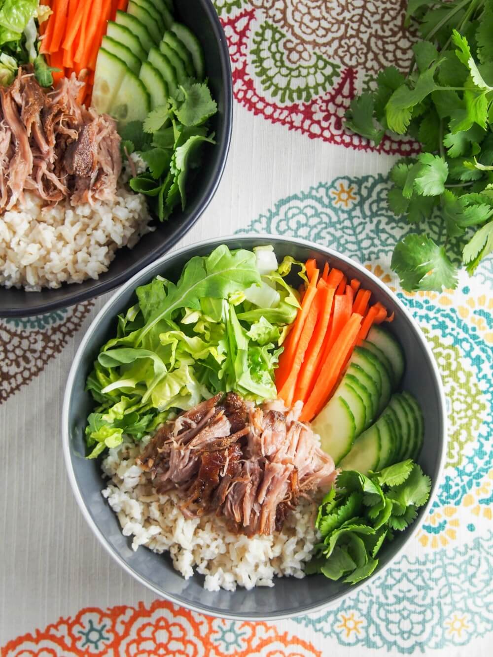 Vietnamese banh mi pork served over rice and salad bowls from above