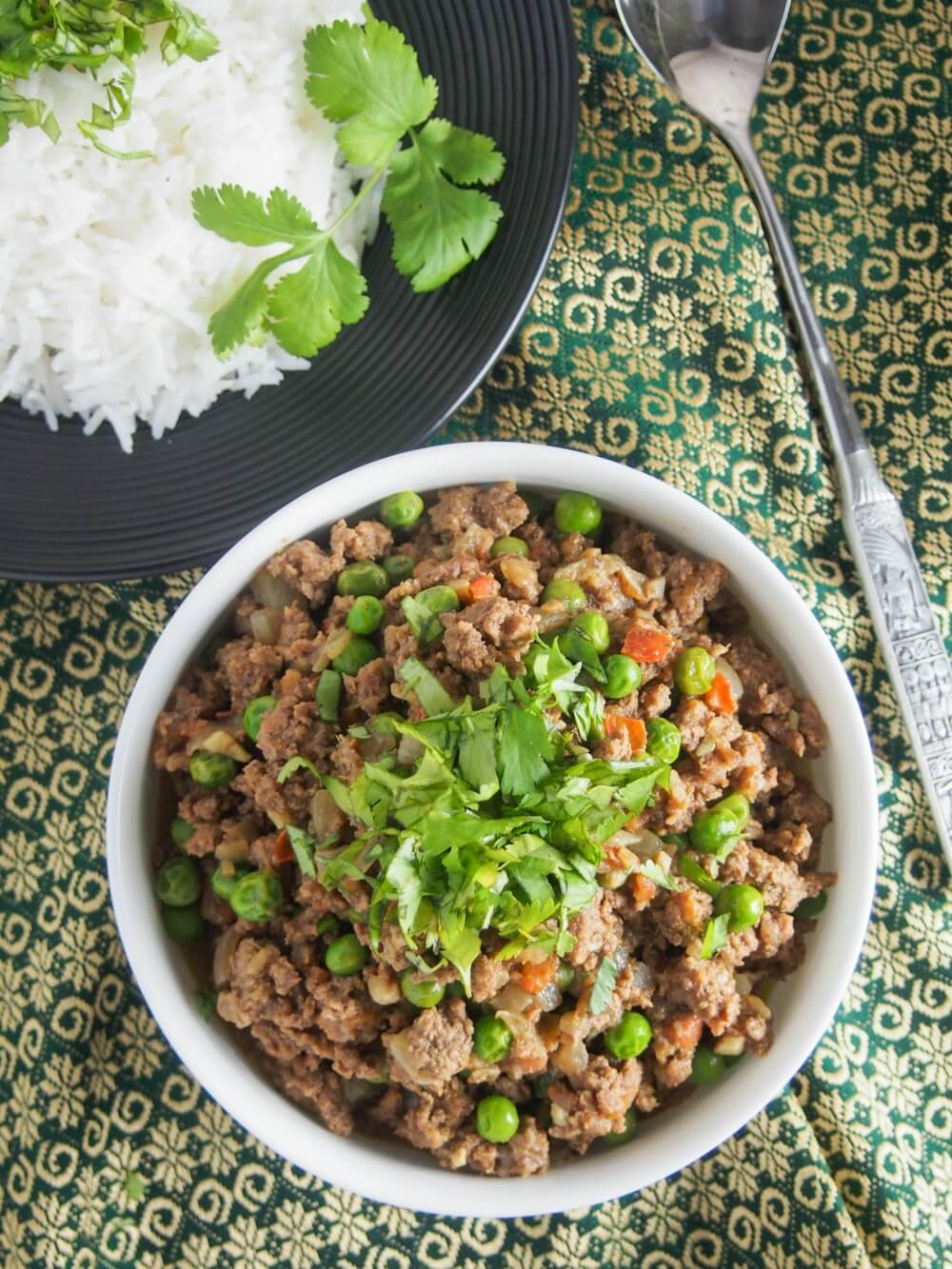 bowl of keema curry from overhead with dish with rice above