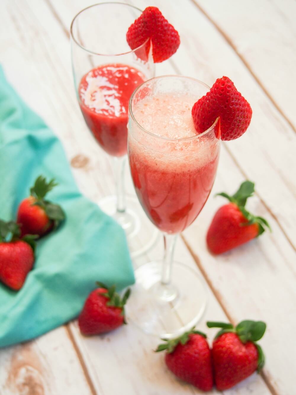 glass of strawberry bellini with second glass just with strawberry puree behind