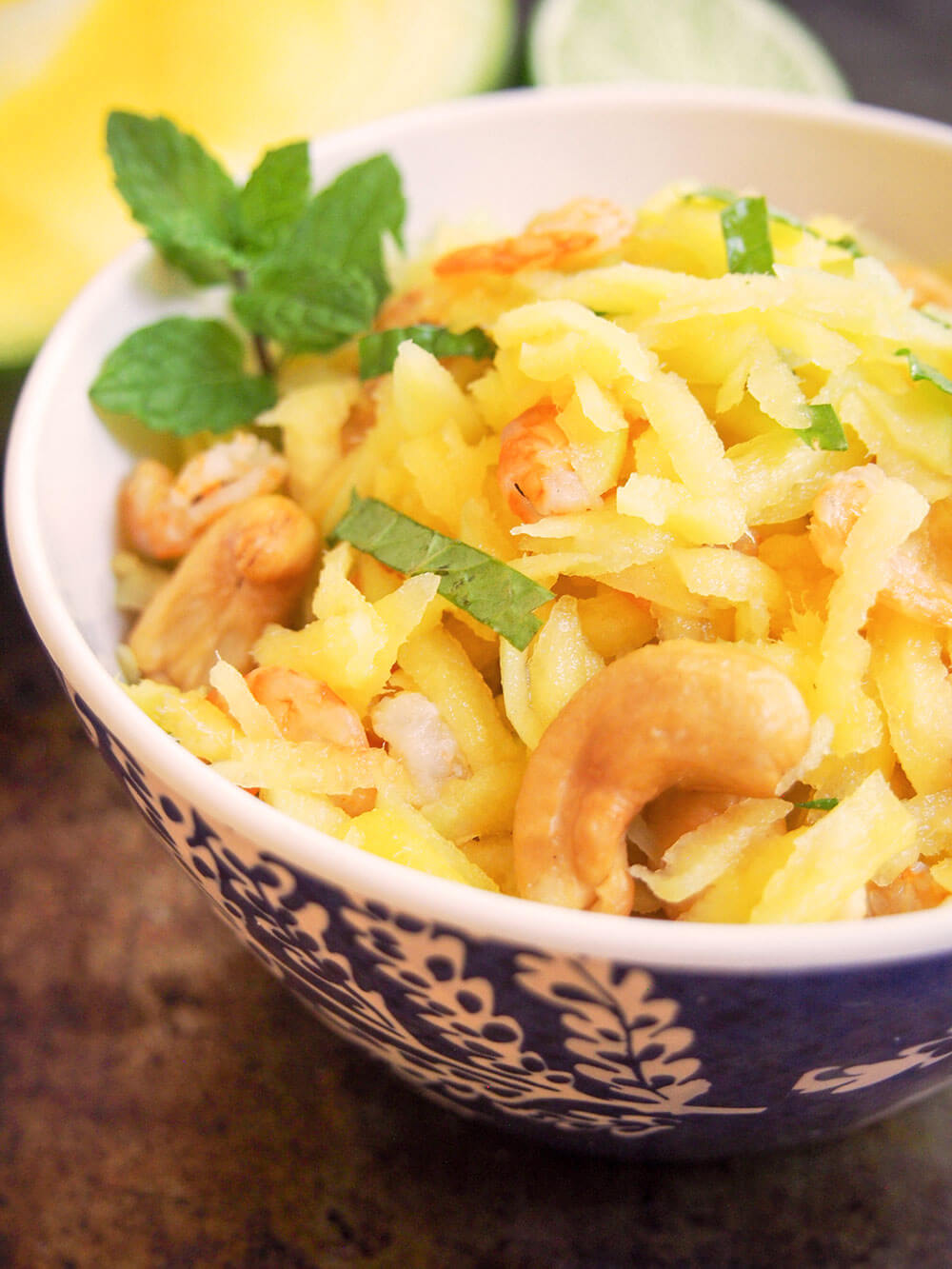 This Cambodian green mango salad is so easy to make and wonderfully fresh. Don't be put off by dried shrimp, they add a great flavor and texture to this simple, light side/appetizer perfect for summer. side view of bowl of Cambodian green mango salad