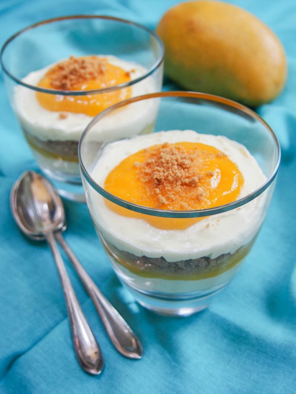 mango cheesecake parfait in glasses showing layers through glass