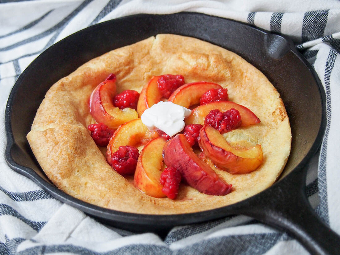 If you're looking for an easy breakfast/brunch that's packed with flavor, this peach Dutch baby pancake has to be high up the list. The roast peaches take this simple baked pancake from good to amazingly delicious! peach Dutch baby pancake in skillet