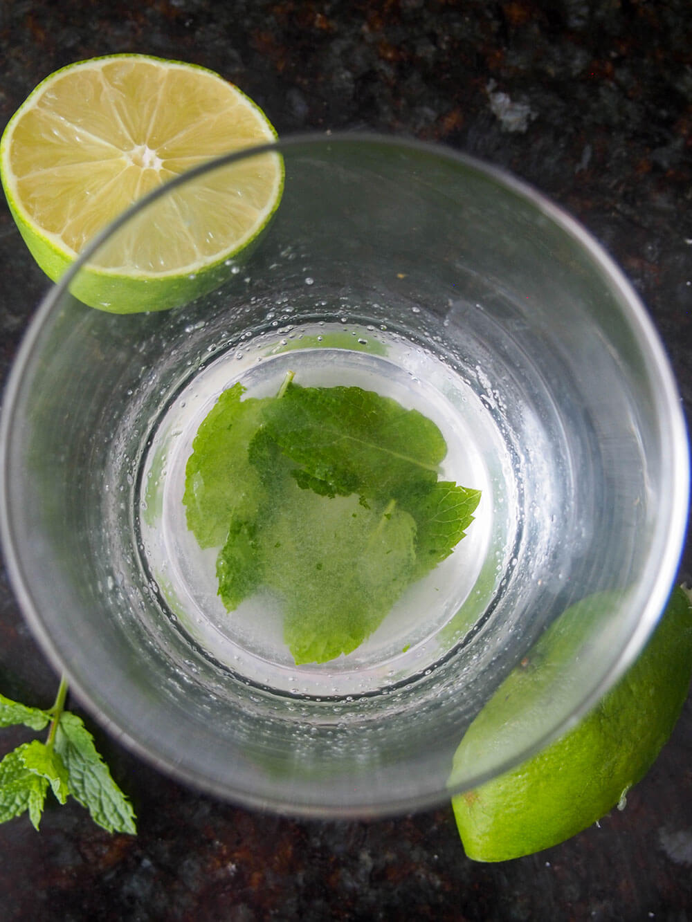muddling lime, mint and sugar in glass muddling lime, sugar and mint in glass