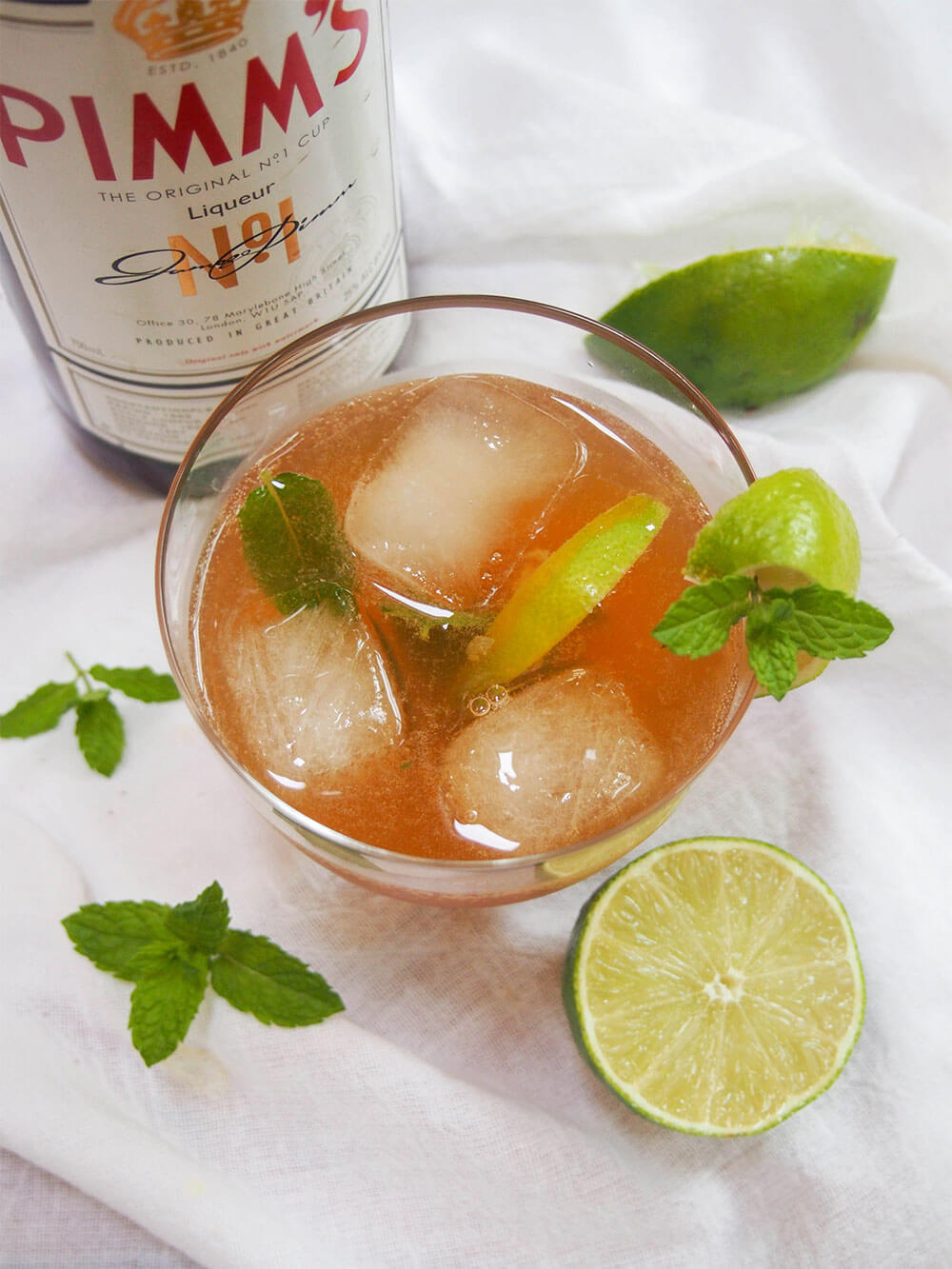 This Pimm's mojito is an alternative Pimm's cocktail that's just as refreshing as the classic Pimm's cup, and perfect for summer. So easy to make too. pimm's mojito with Pimm's bottle behind and lime in front