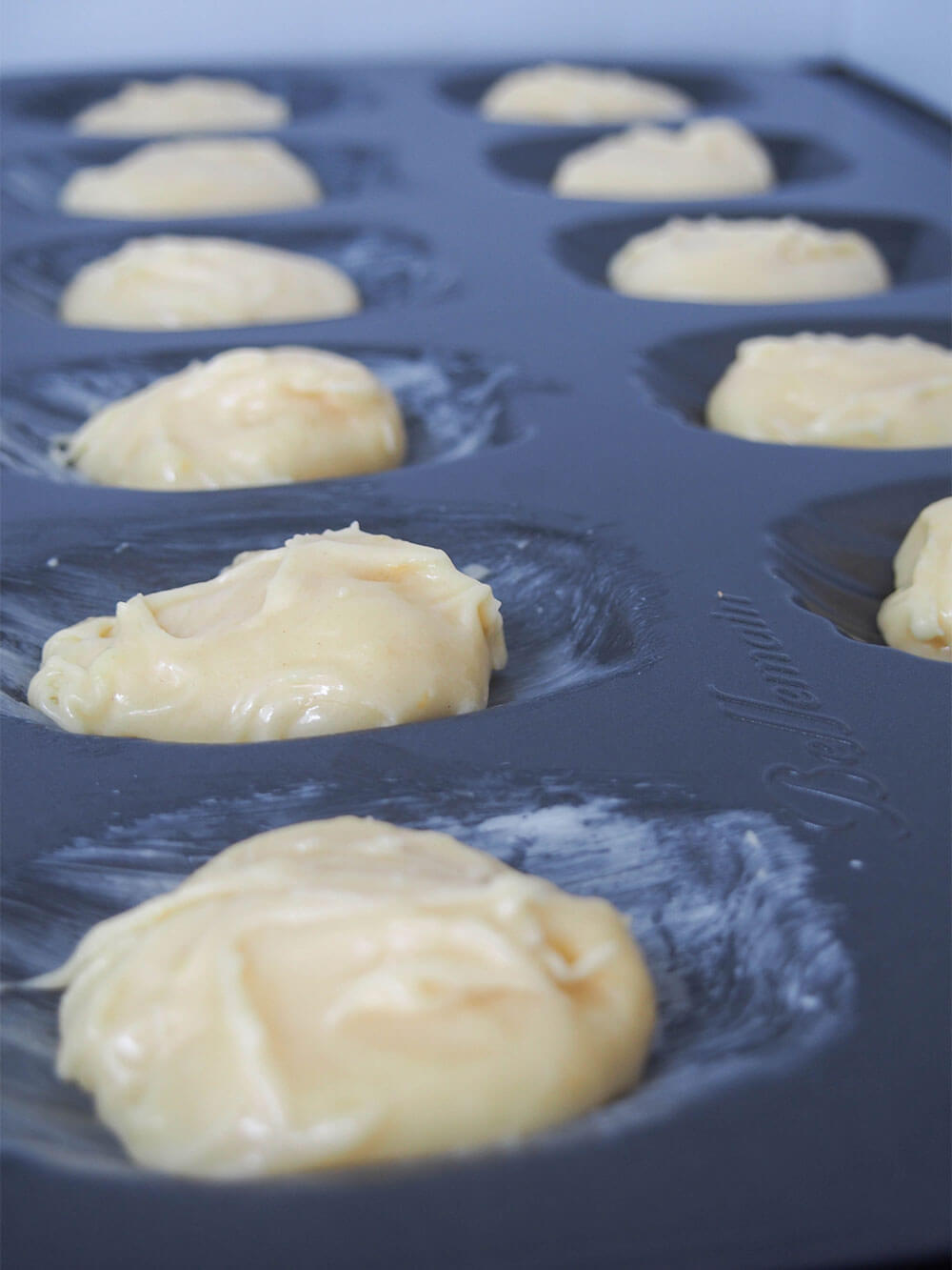 filling moulds for lemon madeleines with batter filling moulds for lemon madeleines with batter