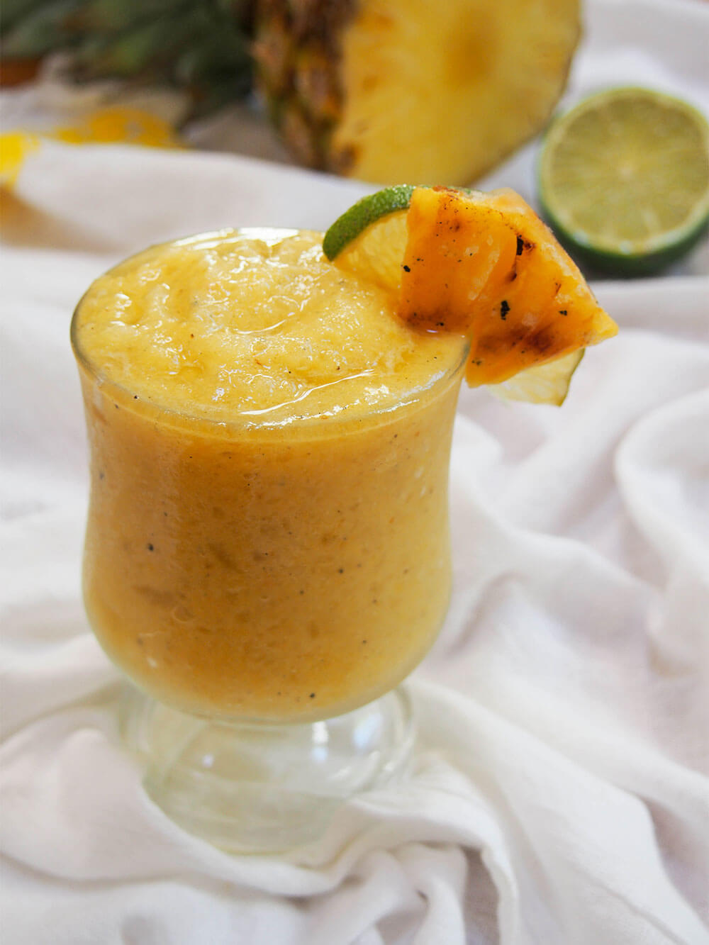 frozen pineapple daiquiri with grilled pineapple and lime garnish