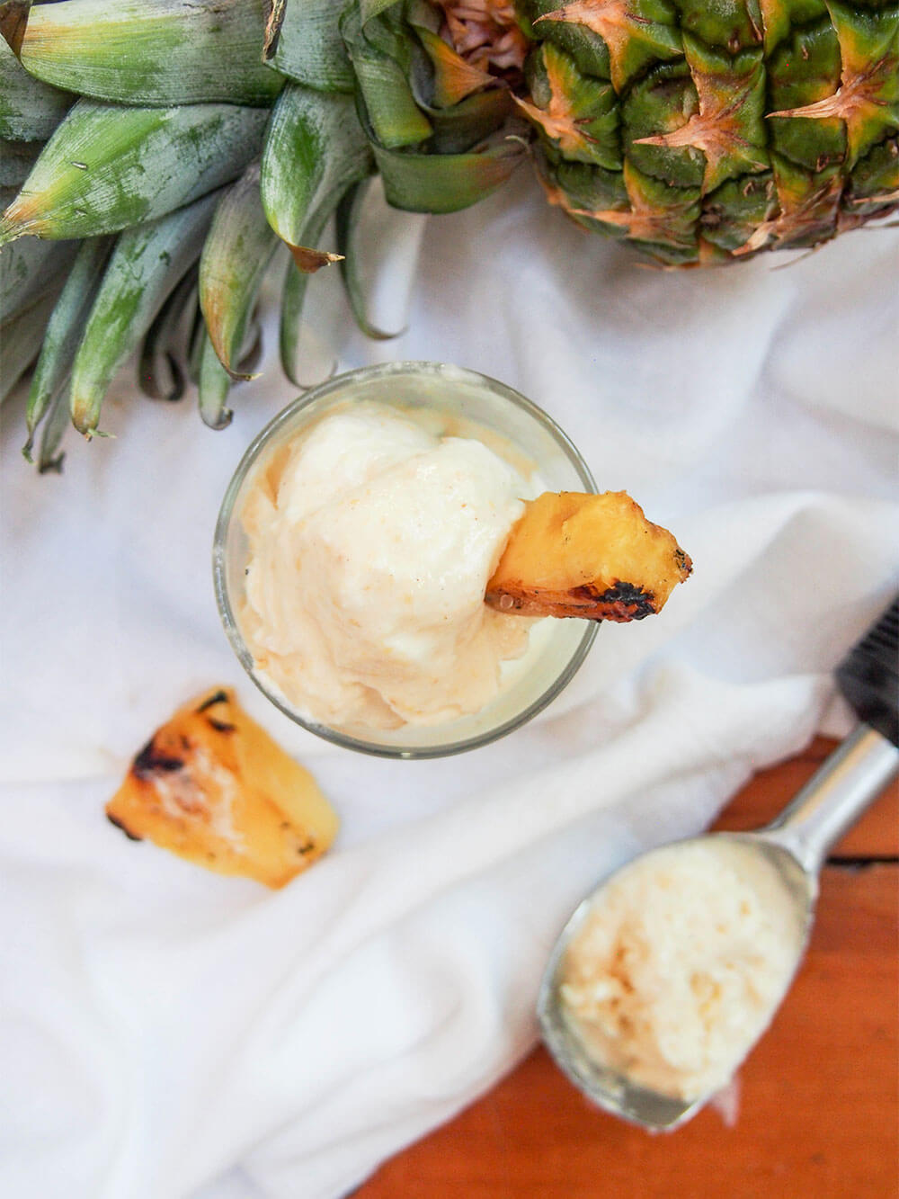 grilled pineapple ice cream in glass from overhead with scoop to side