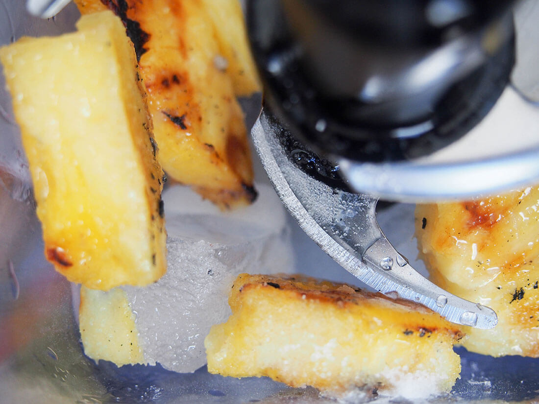 grilled pineapple chunks and ice in blender
